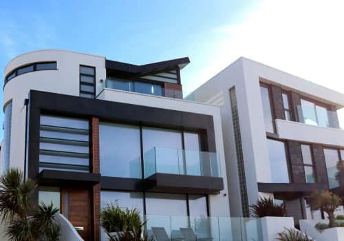 Contemporary luxury home with glass balconies in Poole, UK, showcasing modern architectural design.